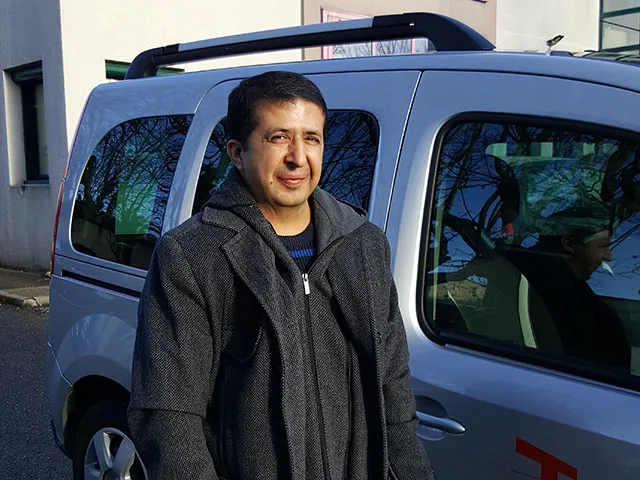 Photo de Samir, chauffeur, devant son véhicule