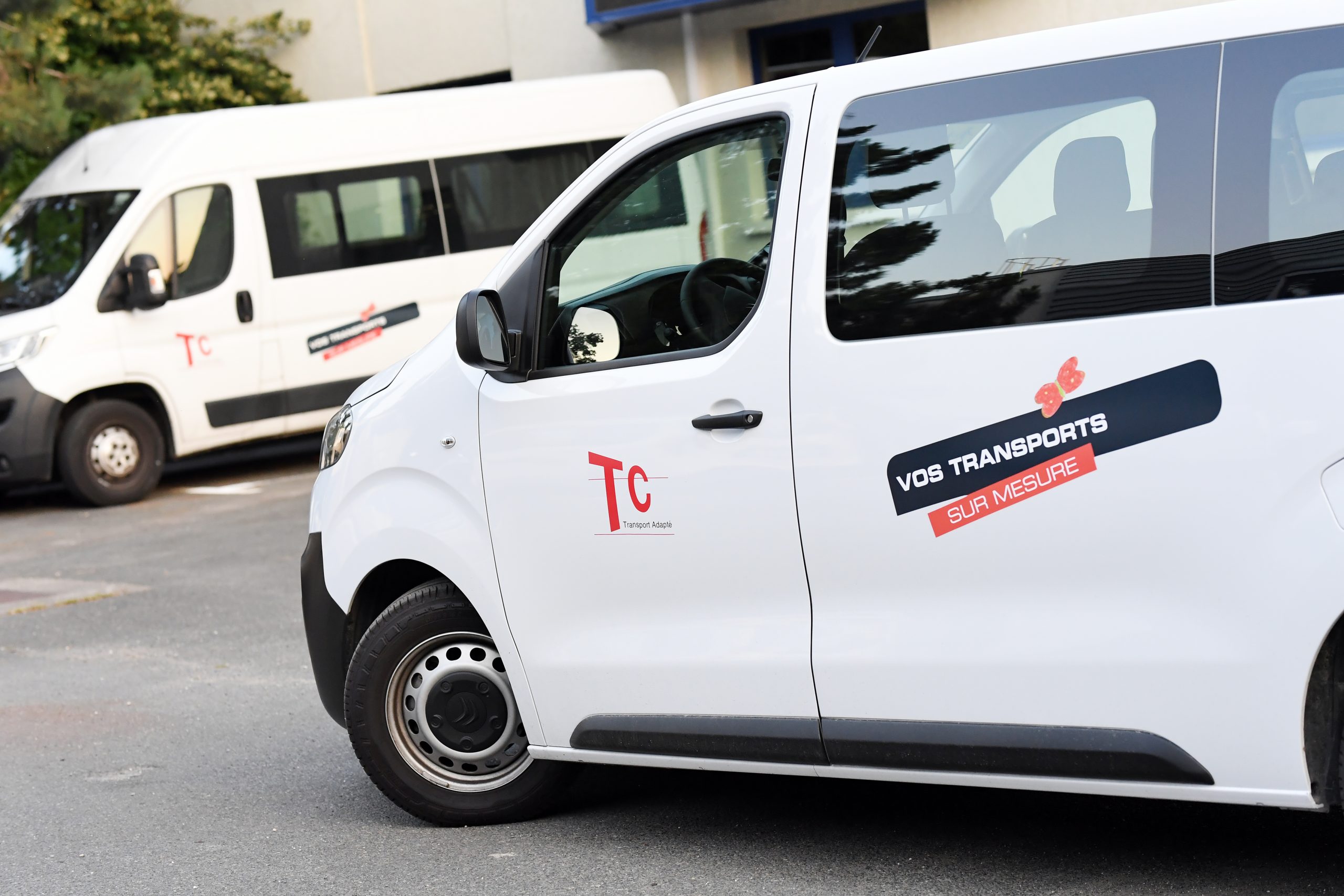 Photo de 3 personnes dont une en fauteuil devant un véhicule aménagé TC Transport
